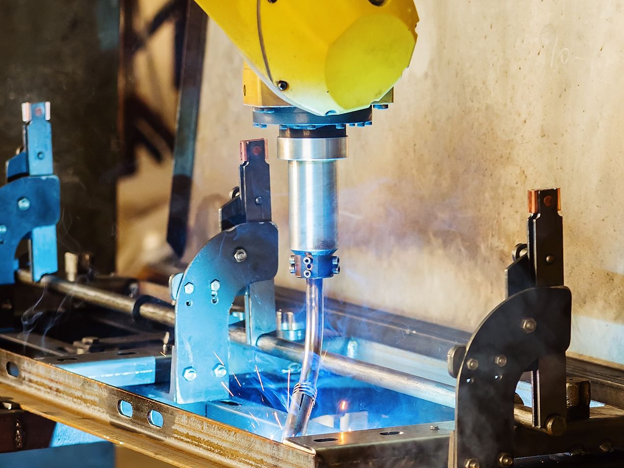 Robot holding a welding nozzle at the workpiece